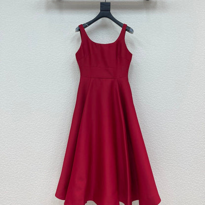 Red dress hanging on a black hanger against a white wall